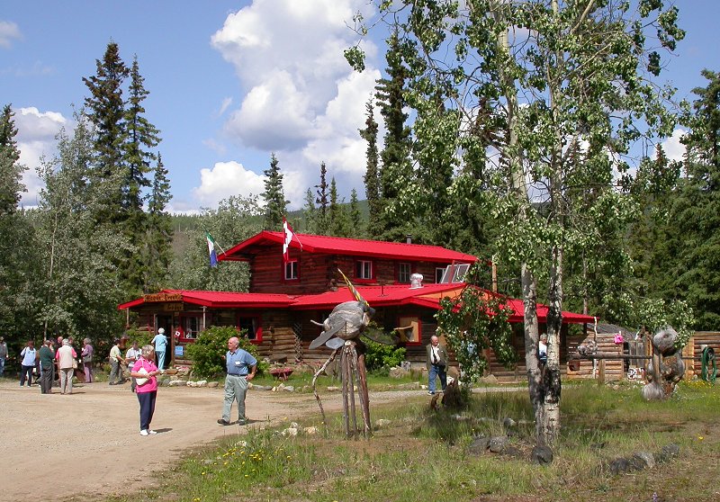 Visitors exploring the forests and log sculptures around Moose Creek Lodge, Yukon Territory